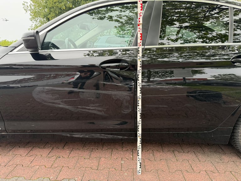 Messstab an der Fahrertür zur Bestimmung der Schadenshöhe über der Fahrbahn