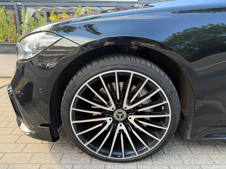 Vorderer Radlauf und Leichtmetallfelge eines dunklen BMW bei der Prüfung auf einen Streifschaden